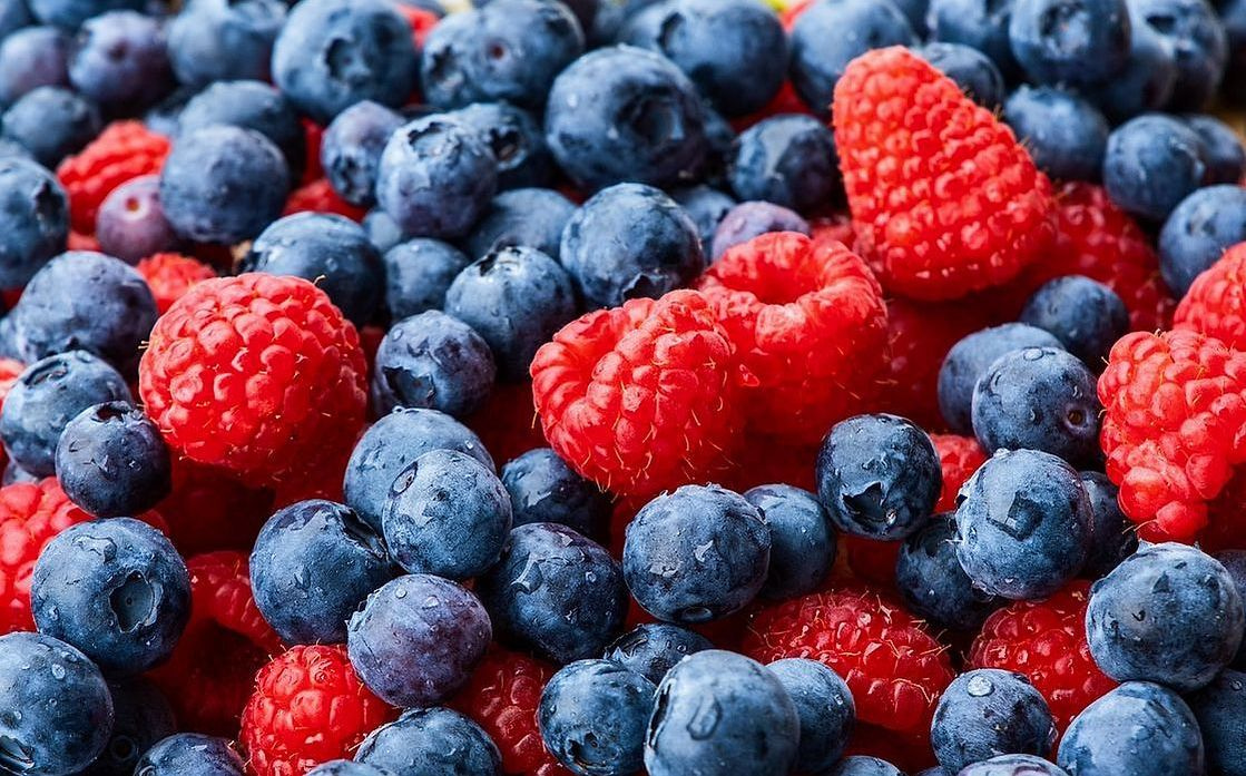 Uvas verdes y moradas en un recipiente de vidrio